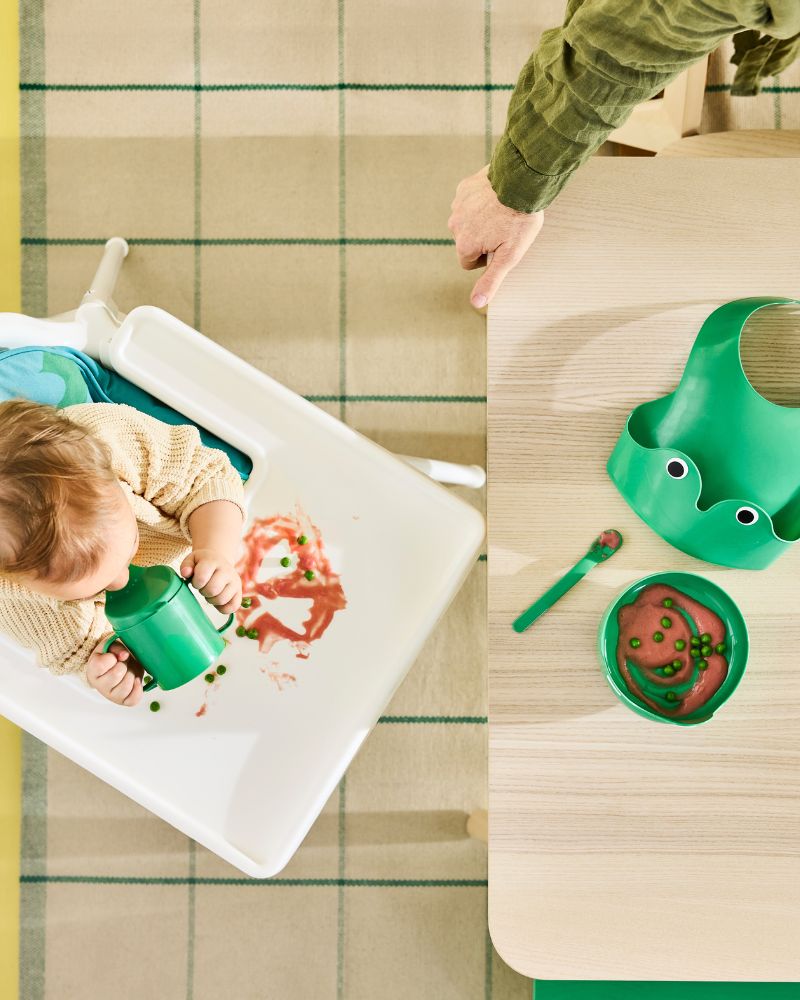 Bright green frog-themed four piece MATA  baby tableware set with bib, bowl, sippy cup  and spoon.