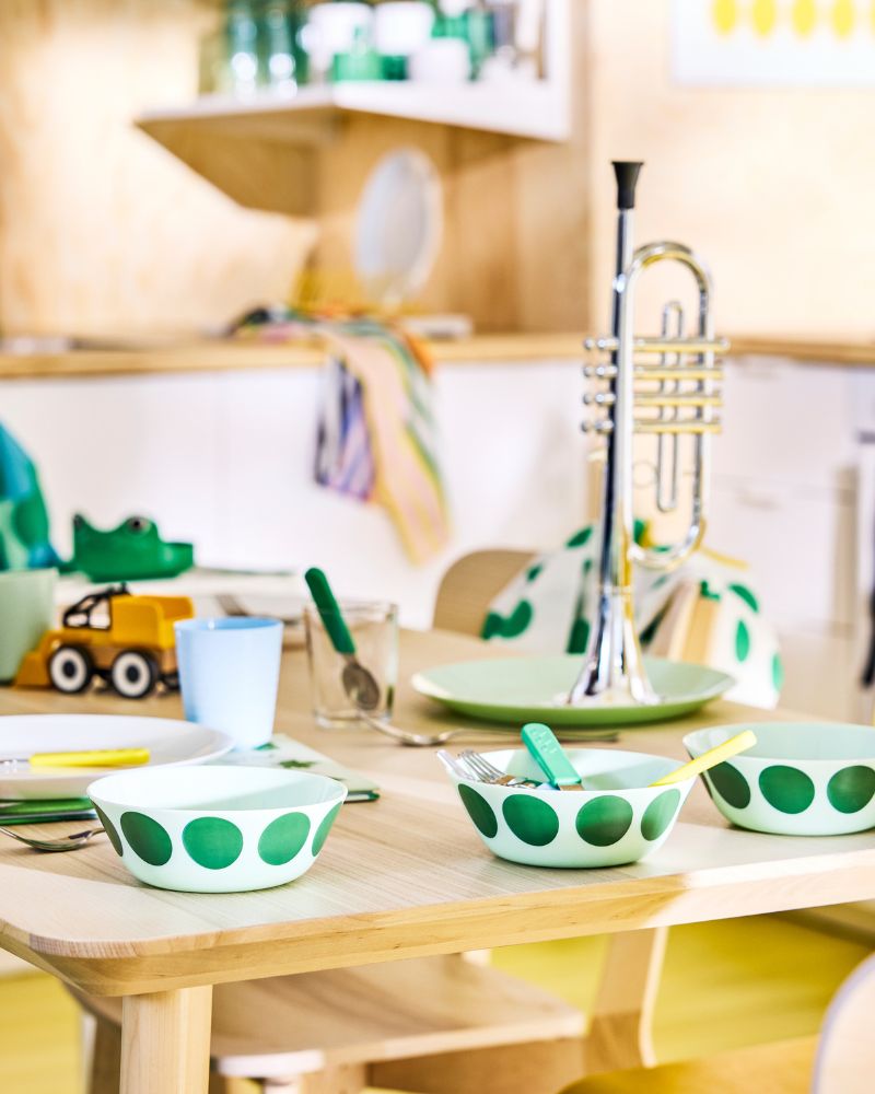 OFTAST bowls with green spot motif on a  family dinner table in a Scandinavian modern  kitchen.