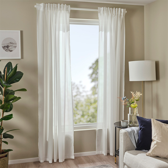 un salón con cortinas blancas sobre una ventana