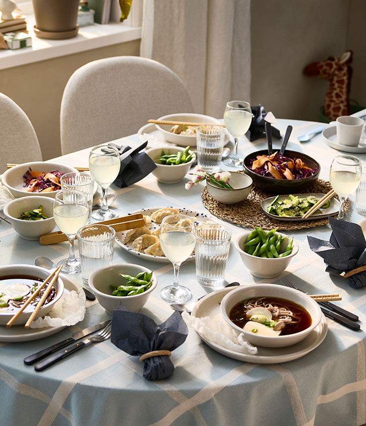 A ROSENTORP extendable table has been set for a festive meal with soup served in bowls and dumplings on a serving plate.