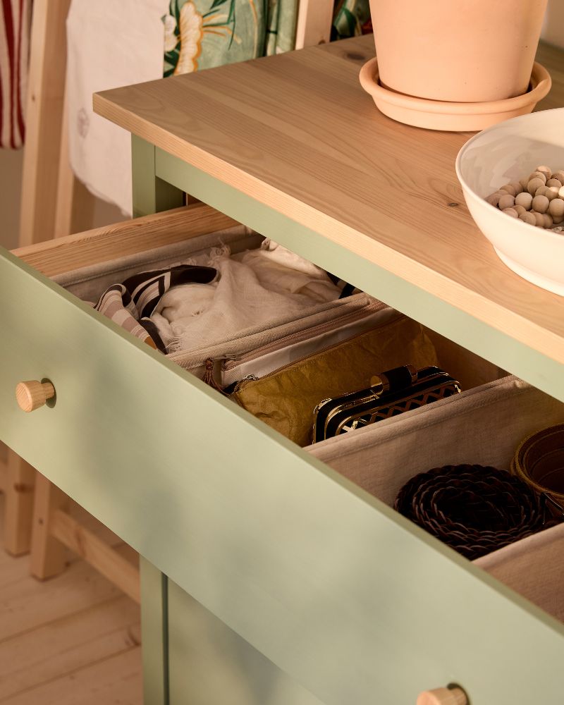 Close-up of HEMNES chest of drawers with the top drawer pulled out, to show the neat order inside with PURRPINGLA boxes.