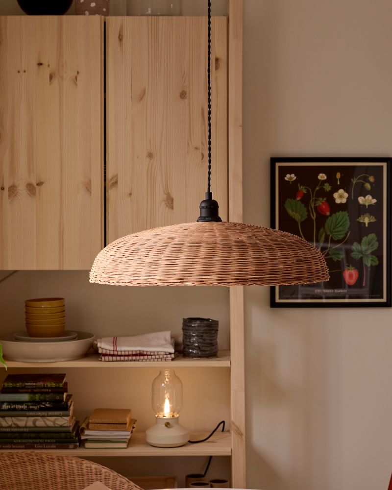 NARRKOLV pendant lamp in rattan hanging above a white ROSENTROP table with IVAR shelving unit behind it.