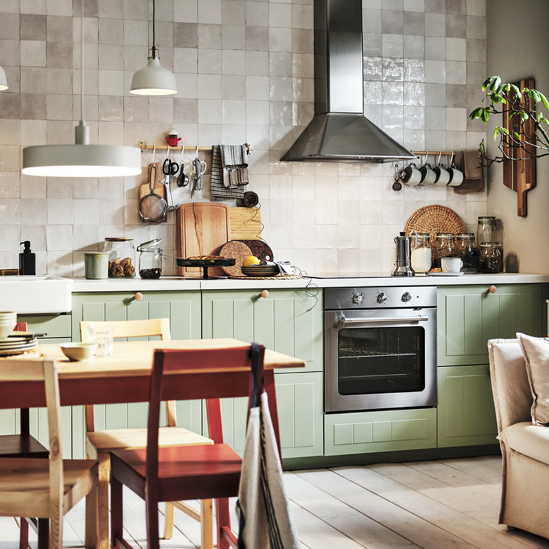 Cocina modular con encimera, la toma es desde abajo para apreciar los frentes y puertas, también se ve la grifería de la cocina y una cafetera, una lámpara y la vajilla.