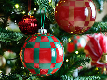 Los adornos para árboles VINTERFINT, con un llamativo diseño a cuadros, adornan las ramas de un festivo árbol de Navidad.