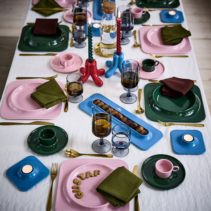 Una divertida mesa navideña decorada con platos, tazas con platillos y candelabros VINTERFINT, diseñados en colaboración con Gustaf Westman.