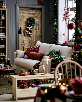 Salón con un sofá de tela beige y una mesa de centro de madera oscura. El espacio está decorado con motivos navideños.