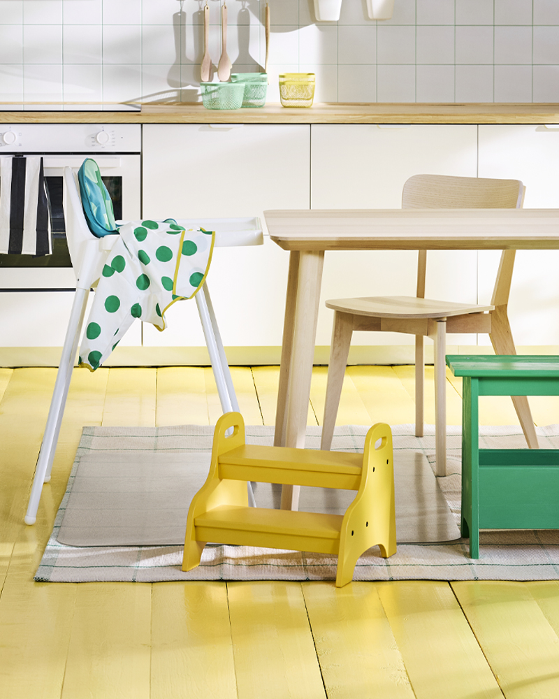 Cocina familiar luminosa con taburete infantil TROGEN, ideal para que los niños alcancen lo que necesitan, participen y se muevan con libertad.