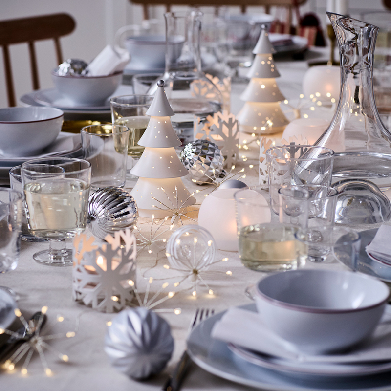 Christmas table dressed in white with table lamps and elegant tableware