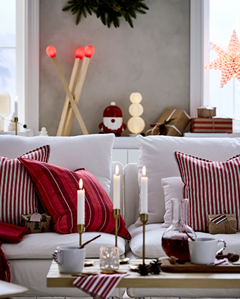 Christmas living room with lit chandelier, red textiles on the sofa
