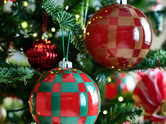 Close-up shot of red and green baubles decorating a tree