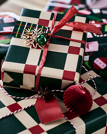 Gifts wrapped in green and red checked wrapping paper, topped with a red bow