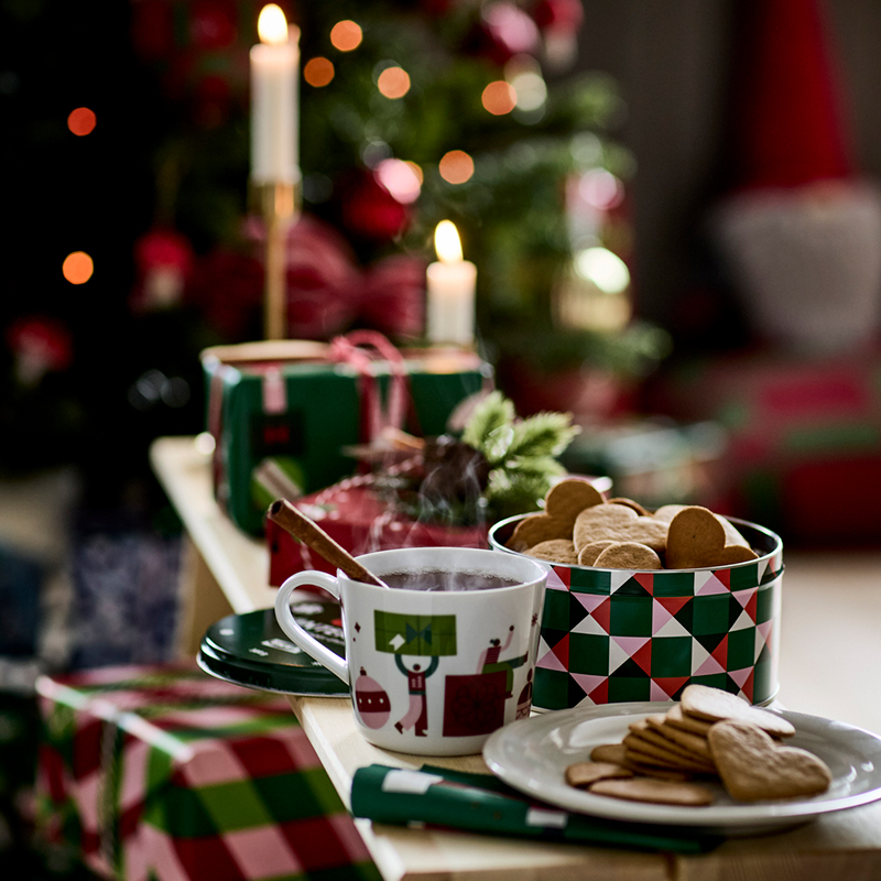 Heart-shaped biscuits and steaming hot chocolate served on Christmas tableware.