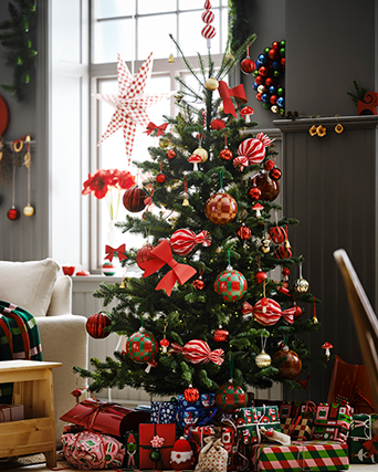 A Christmas tree decorated from top to bottom with red details