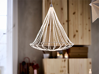 Lámpara colgante de LED con diseño cónico, minimalista y festivo, formada por múltiples líneas de luz blanca sobre un fondo de muebles de madera clara.