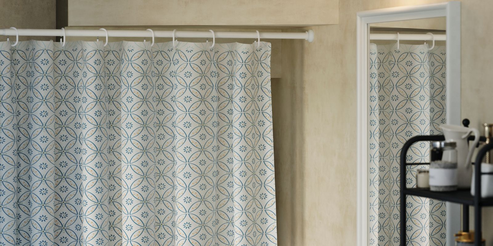 Una barra para cortina de ducha BOTAREN en color blanco se coloca bajo una escalera en un aseo pequeño, con una cortina que oculta las estanterías.