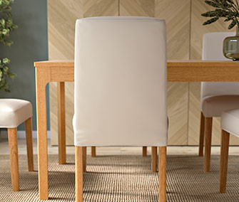 Close-up of a dining chair with a beige fabric cover, light-wood legs, and a high backrest.