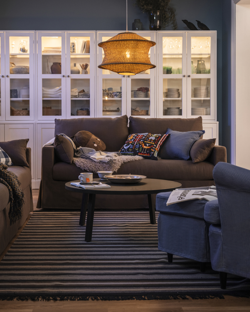 A BLÅSTÅNG pendant lamp hangs in a living room with two grey-brown HYLTARP sofas and a STOCKHOLM 2025 coffee table.