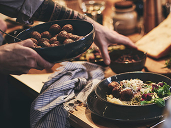 Alguien acomodando los platos con albondigas para comer