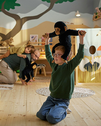 Padre e hijo jugando juntos en una sala de juegos acogedora con muebles de madera natural e iluminación suave