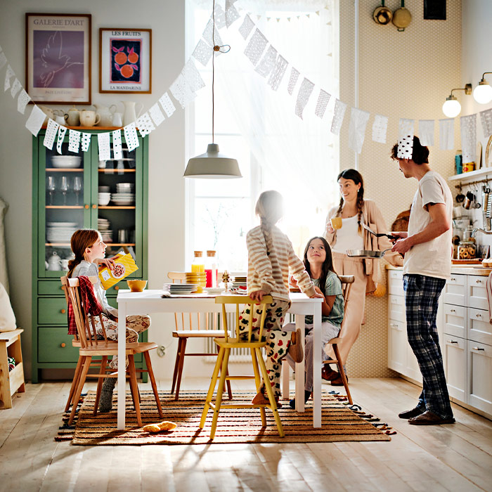 Group at a decorated table in festive setting with natural light. Food and drinks on the table.
