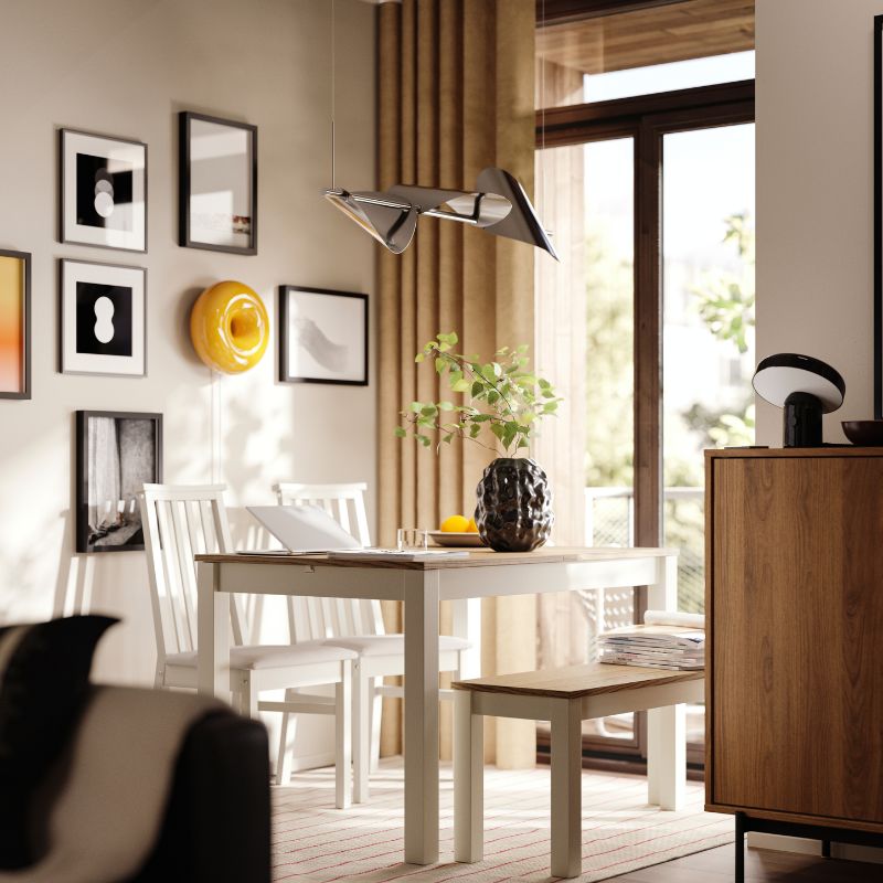 Un área de comedor tiene una mesa extensible ÅLHULT de color beige/marrón con un banco a un lado y dos sillas con asientos blandos al otro.