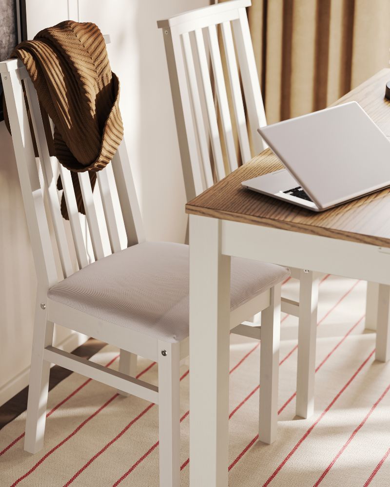 Dos sillas ÅLHULT de color beige con asientos blandos en Kabusa beige claro están colocadas junto a una mesa extensible ÅLHULT de color beige/marrón.