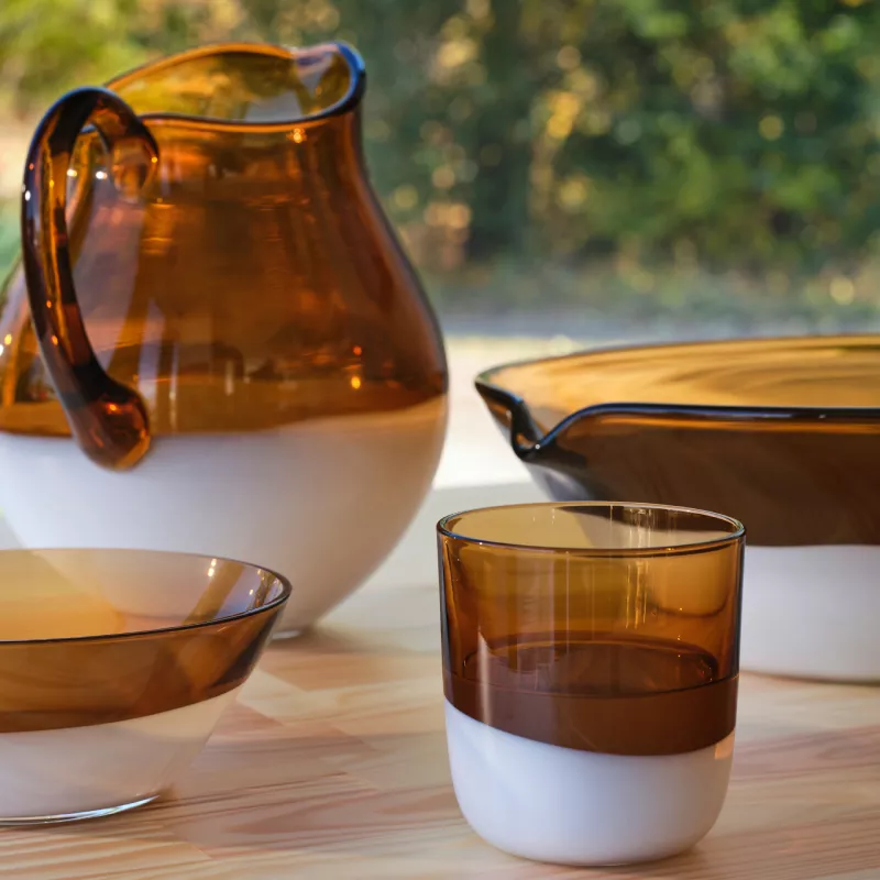 Rustic OMMJÄNGE jug, cups, and bowls in a close-up shot on a neutral surface.