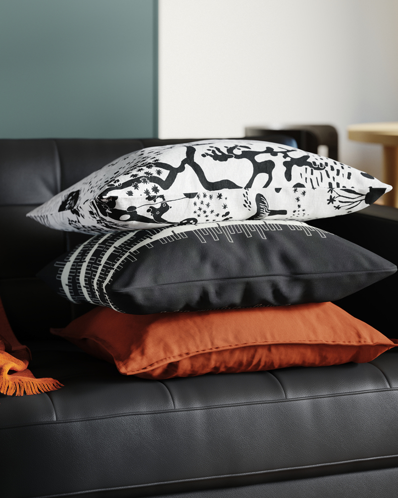 Tres cojines descansan sobre un sofá de tres plazas de cuero y tela revestida en una sala de estar digna de Instagram.