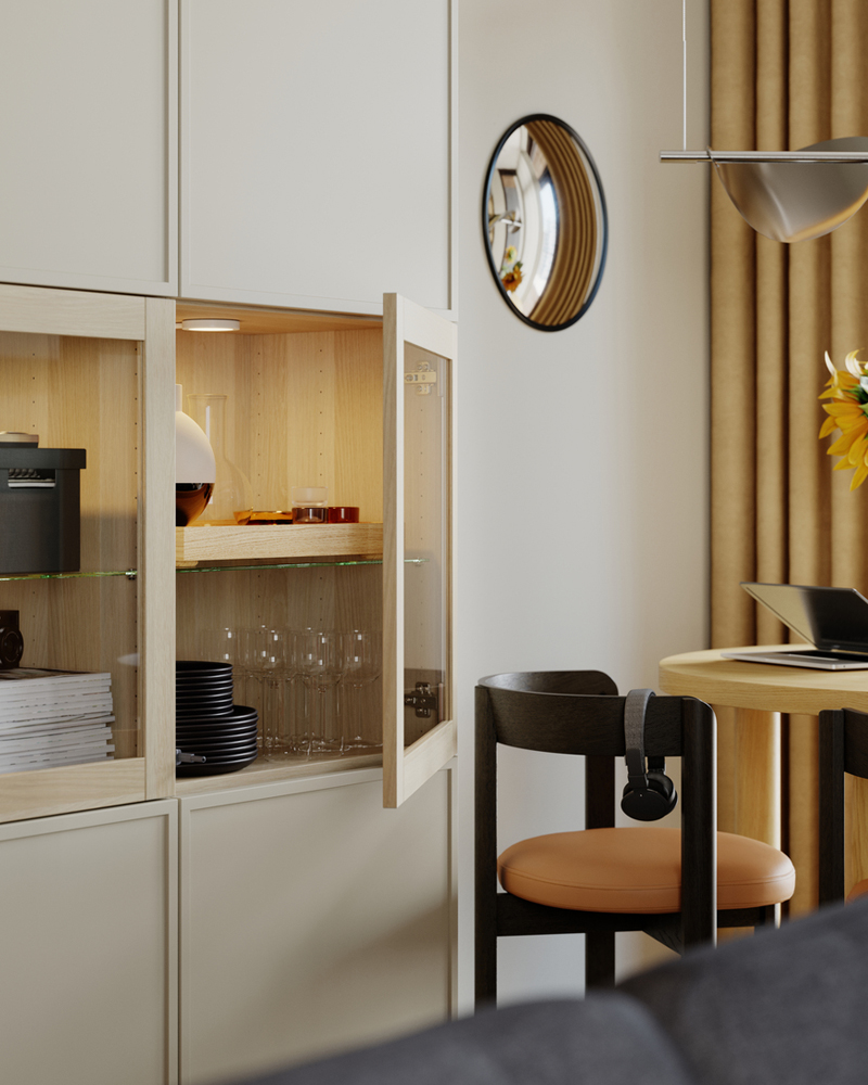 Mini cómodas FJÄDERHARV con dos cajones y otros objetos dentro de una combinación de almacenaje BESTÅ con puertas que se abren una de ellas.