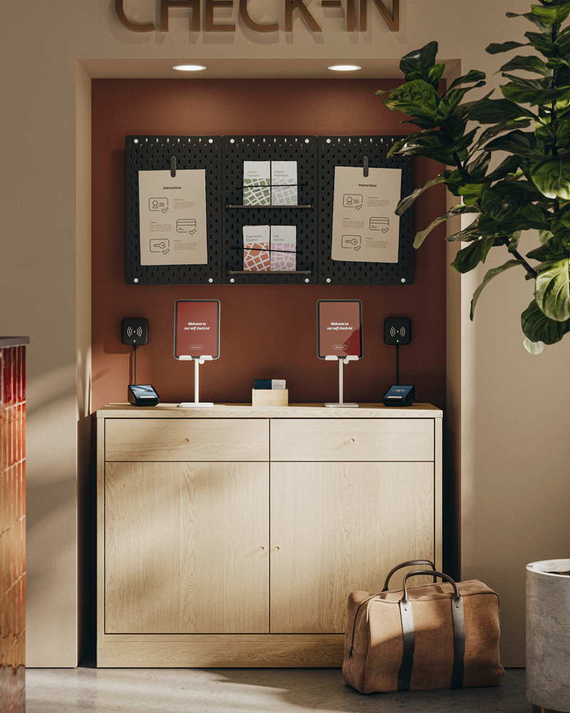  Estación de auto check-in en recepción, con aparador TONSTAD con chapado de roble, donde se guardan las tabletas para el check-in, los folletos y la información.