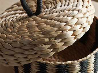 A MÄVINN box with lid. The detailed braiding technique is visible, as is the black cotton loop at the top of the lid.