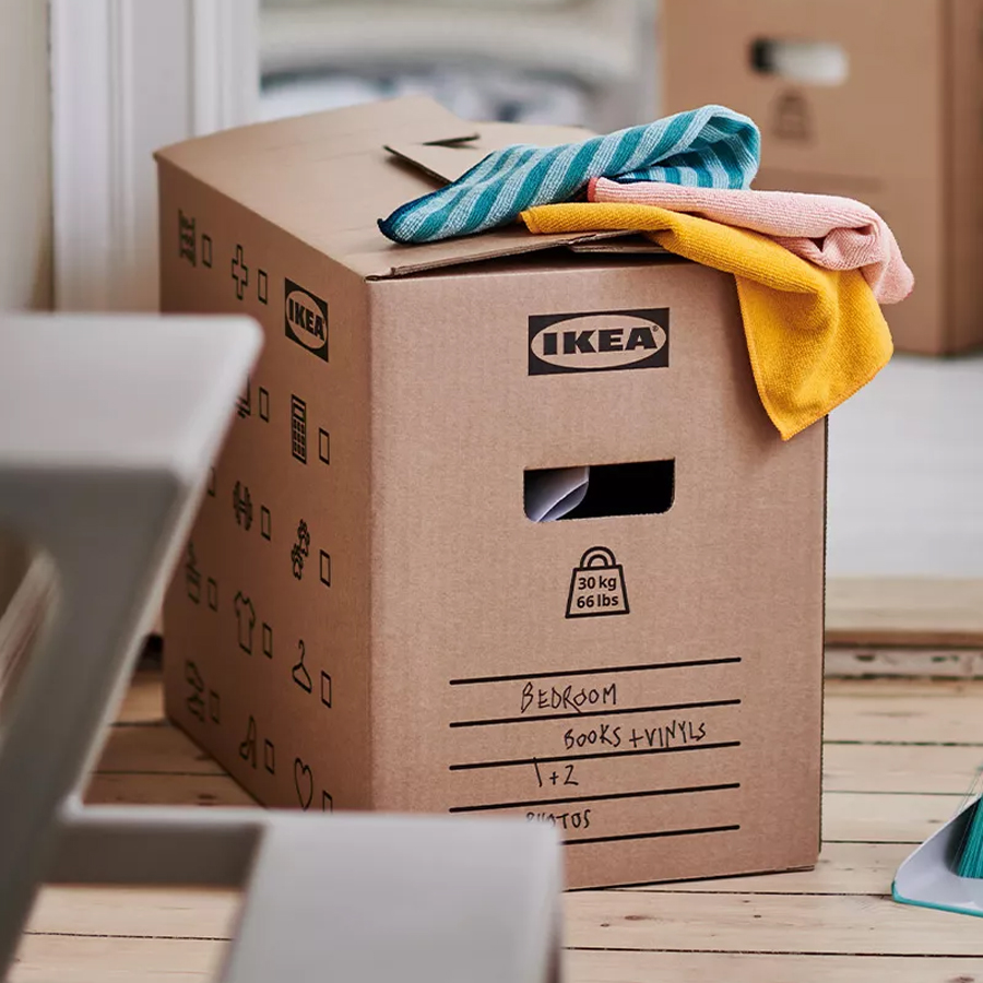Caja de mudanza de cartón con textiles doblados encima, lista para organizar y empacar.