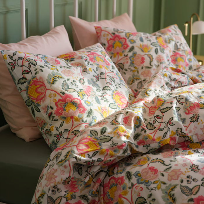 A multicolour DAGGSALVIA duvet cover and pillowcase set featuring a vibrant floral pattern, beautifully arranged on a bed.