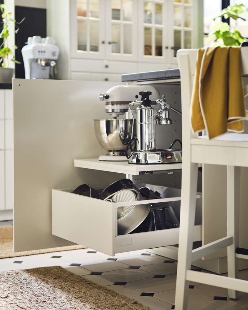 Una cocina con superficie de trabajo extraíble UTRUSTA extendida, con una batidora de pie con bol y colocada sobre un cajón.