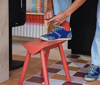 Montón de regalos envueltos con papel a cuadros verdes, blancos y rojos. El regalo superior está atado con una cinta roja.