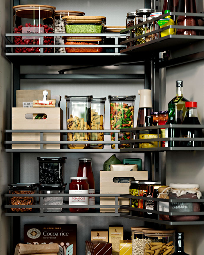 Despensa organizada con cestas de metal gris, botes de cristal con legumbres y cajas de madera clara. Todo en orden y a la vista.