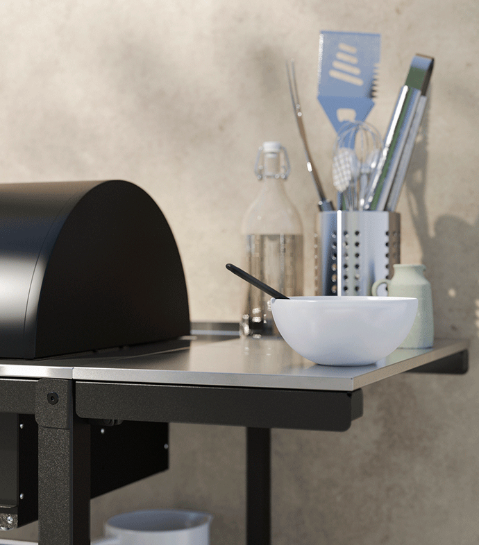 Solid wood kitchen trolley on wheels used as a prep station with fresh vegetables, herbs, and storage crates on a tiled floor.