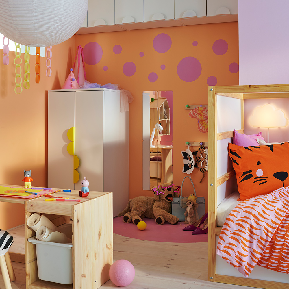 Una estructura TROFAST de pino blanqueado claro y una encimera combinadas para crear un escritorio en el dormitorio de un niño, junto con un armario SMÅSTAD.