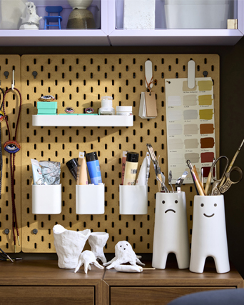 Close-up of a wall pegboard with an attached white SKÅDIS 7-piece accessories set, neatly arranged for crafting supplies.