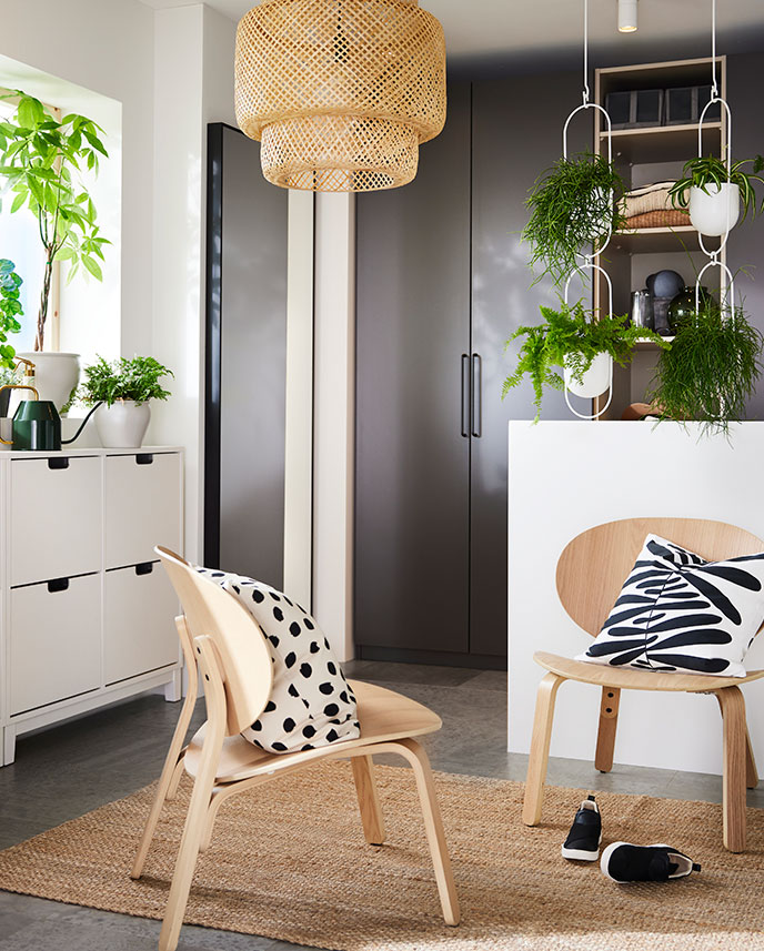 Sobre una alfombra LOHALS hay dos sillas FRÖSET con cojines MAJSMOTT. Al fondo se ven armarios PAX de color gris oscuro