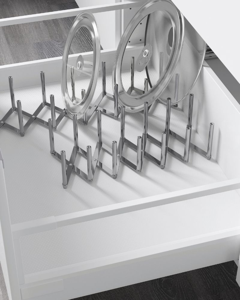 White kitchen drawer with adjustable metal organizer for pot lids. Tidy and functional atmosphere.