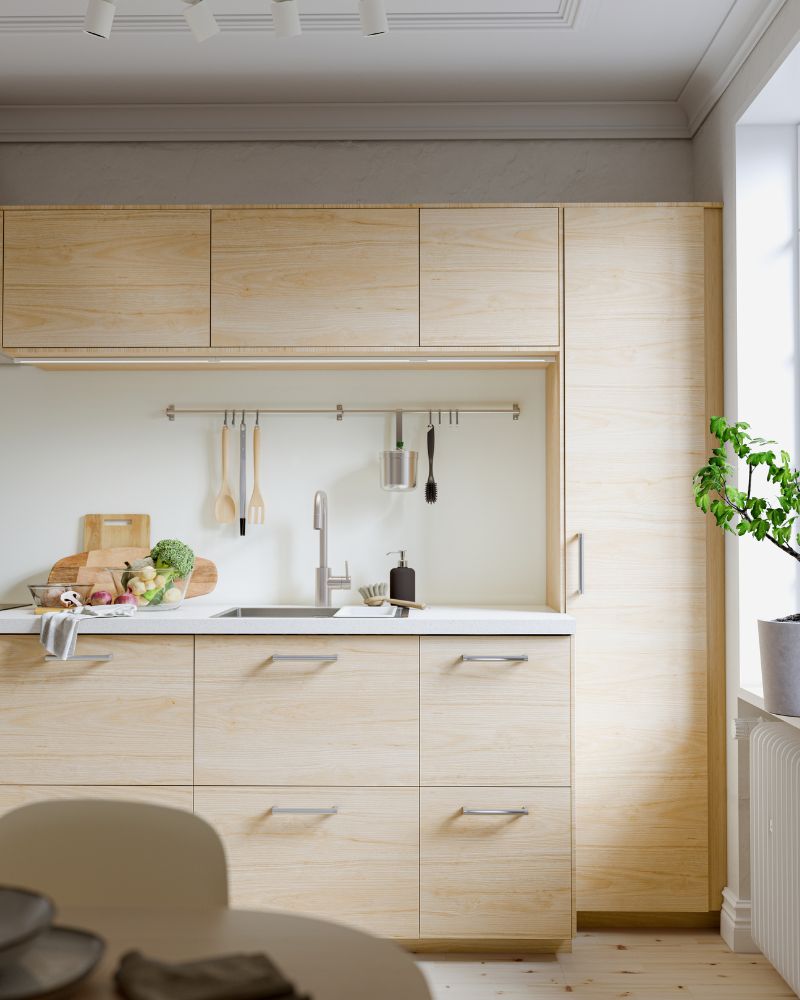 Bright kitchen with light wood cabinets, white marble countertop and backsplash. Open shelves with dinnerware.