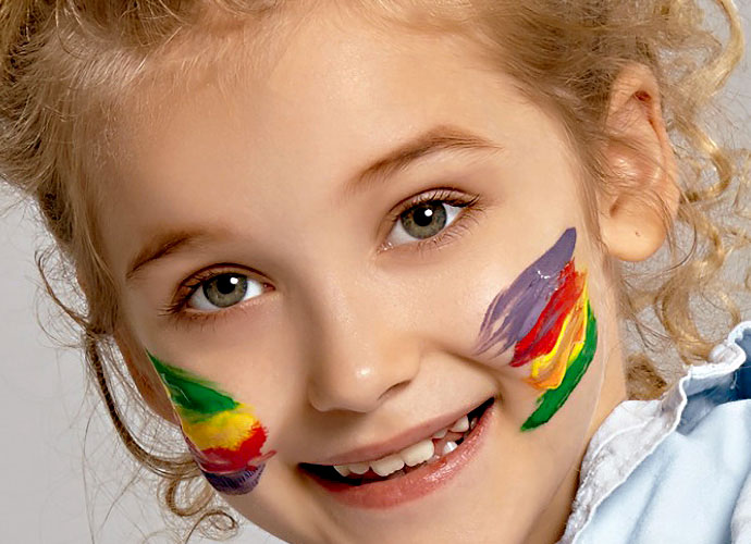 Close-up of a smiling child with colorful paint stripes on their cheeks. Soft curly hair and a joyful expression. Simple and cheerful.