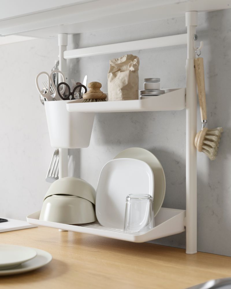 Kitchen setup with SUNNERSTA rail, MÄRKBART scissors, VÄRDERA/OFTAST/GODMIDDAG plates and a GODIS glass on the shelves.