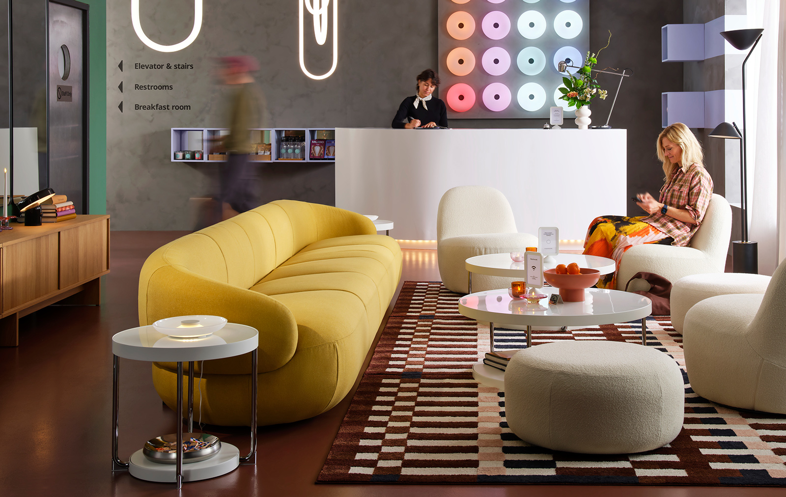 A LILLESÄTER 6-seat sofa in Gunnared bright green-yellow anchors a seating area in a modern hotel lounge with various people.