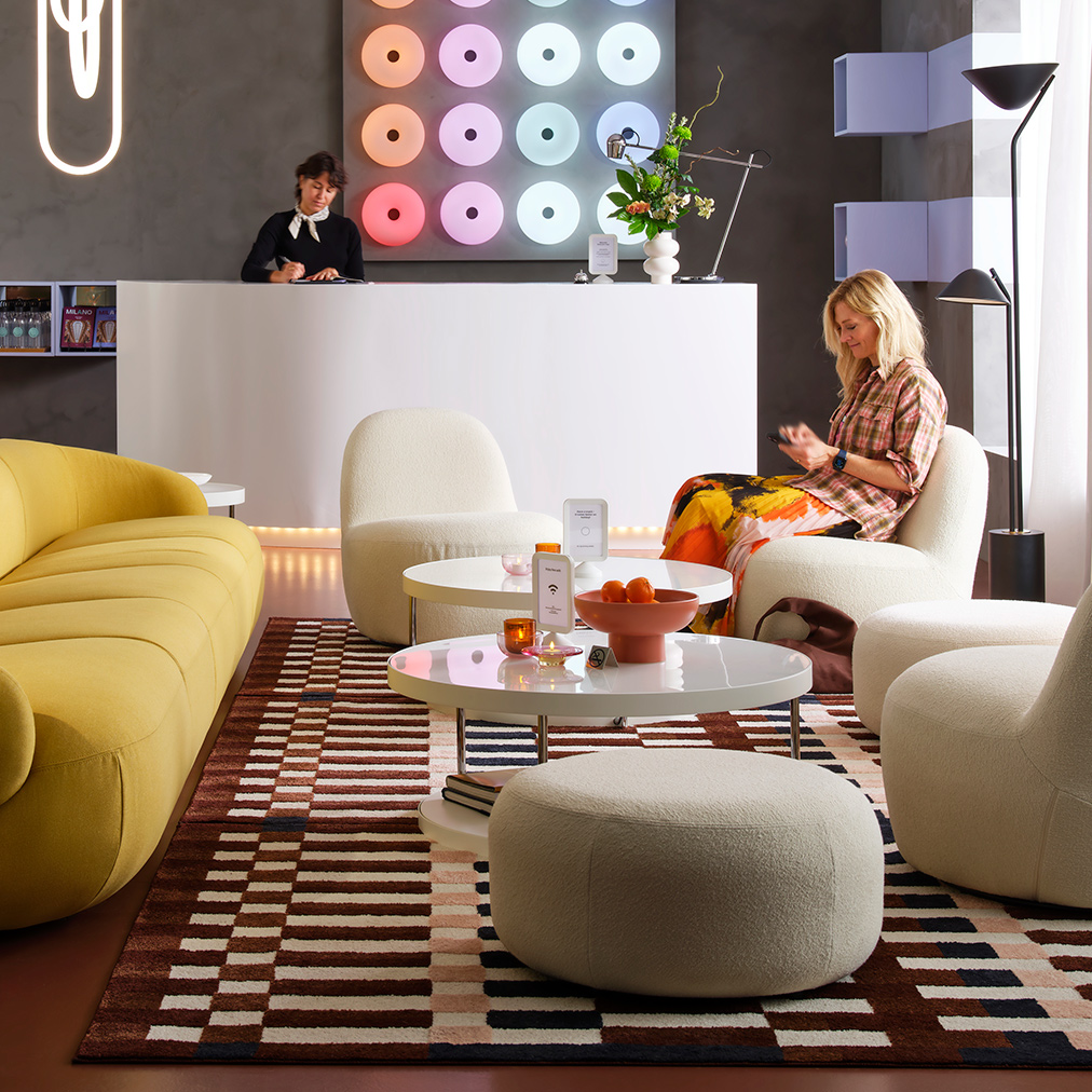A LILLESÄTER 6-seat sofa in Gunnared bright green-yellow anchors a seating area in a modern hotel lounge with various people.