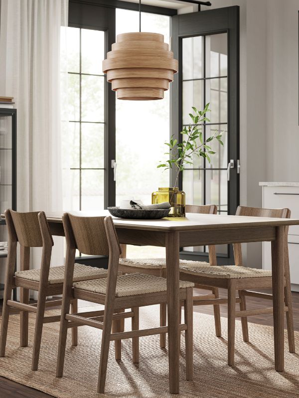 Comedor natural con pantalla DYKARKLOCKA, mesa SKANSNÄS, alfombra LOHALS, cortinas LILL y florero KONSTFULL.