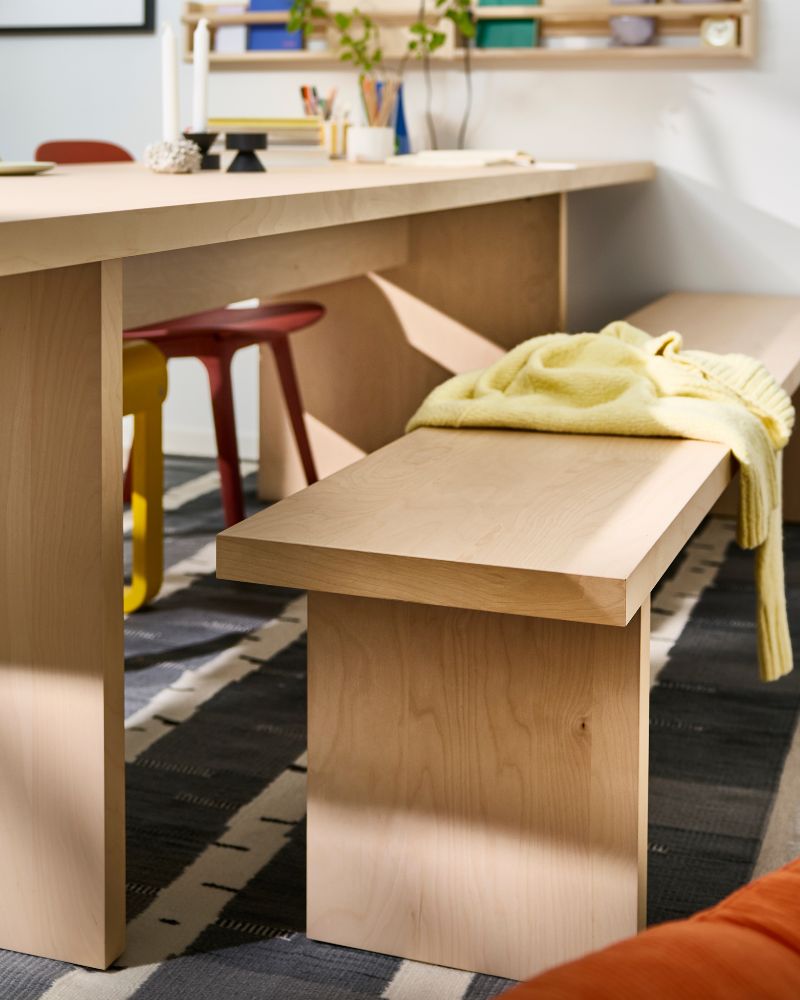 Comedor luminoso con BERGSHYTTAN banca, ODGER silla, STOCKHOLM 2025 candelero y FLISAT almacenaje de pared.