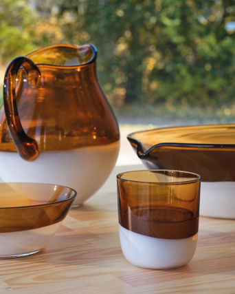 Glass jugs, bowls, and glasses grouped together on a table