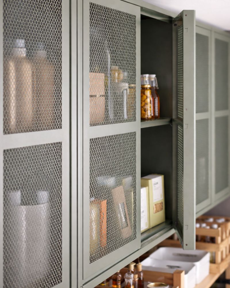 Open metal cabinet with neatly arranged canned goods inside; appears to be part of a food storage area.